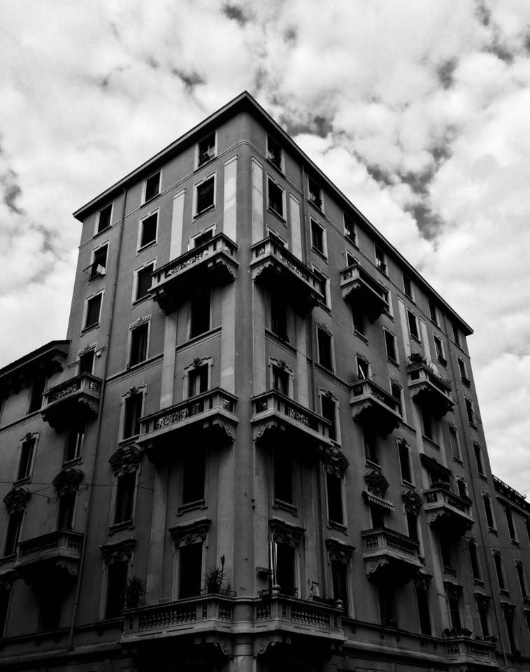 Palazzo d'angolo in bianco e nero sotto le nuvole