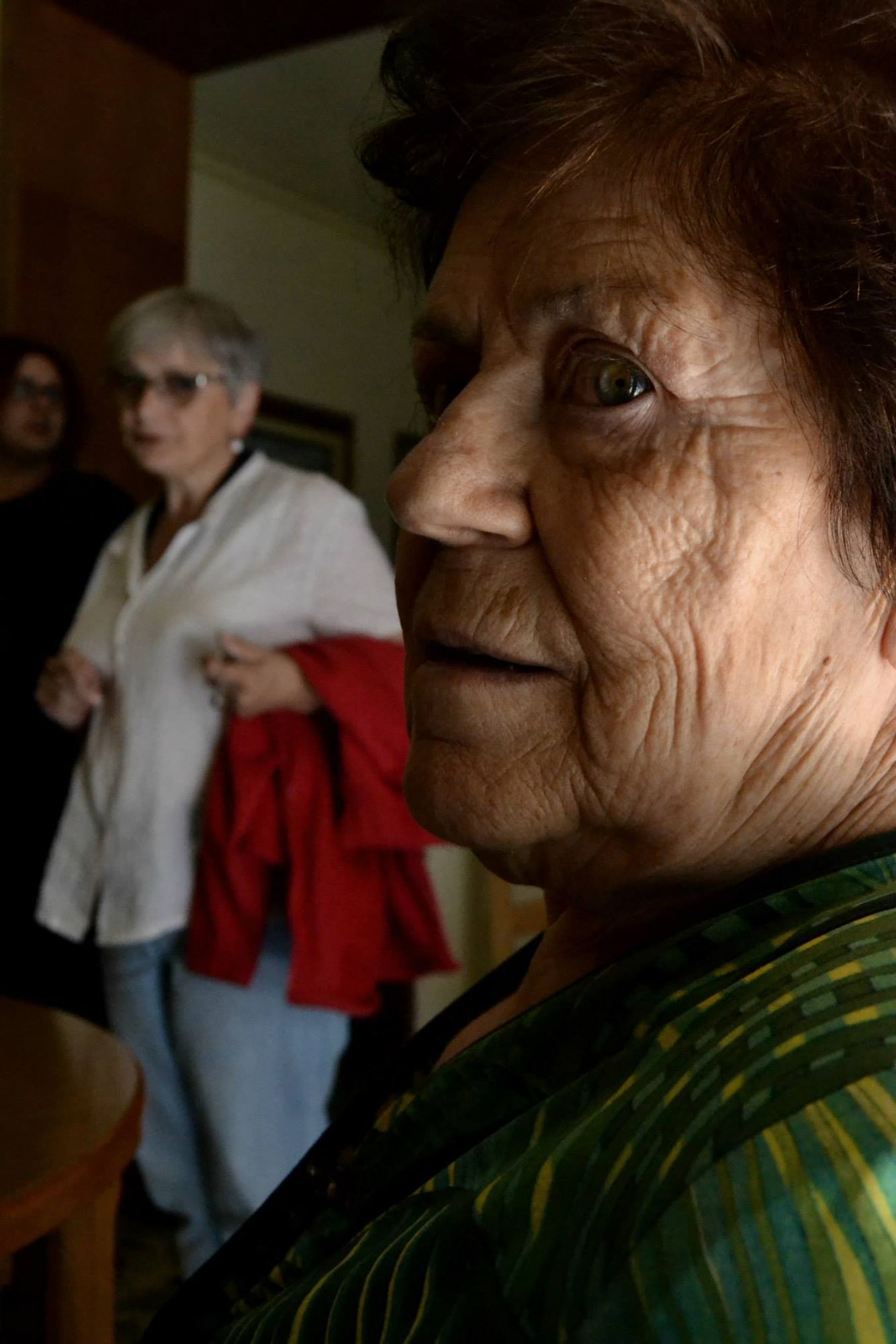 Ritratto ravvicinato di una donna anziana, figure sullo sfondo