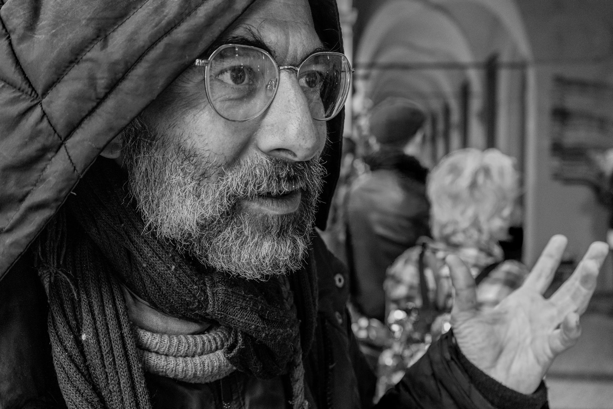 Ritratto in bianco e nero di un uomo con la barba sotto i portici di Bologna