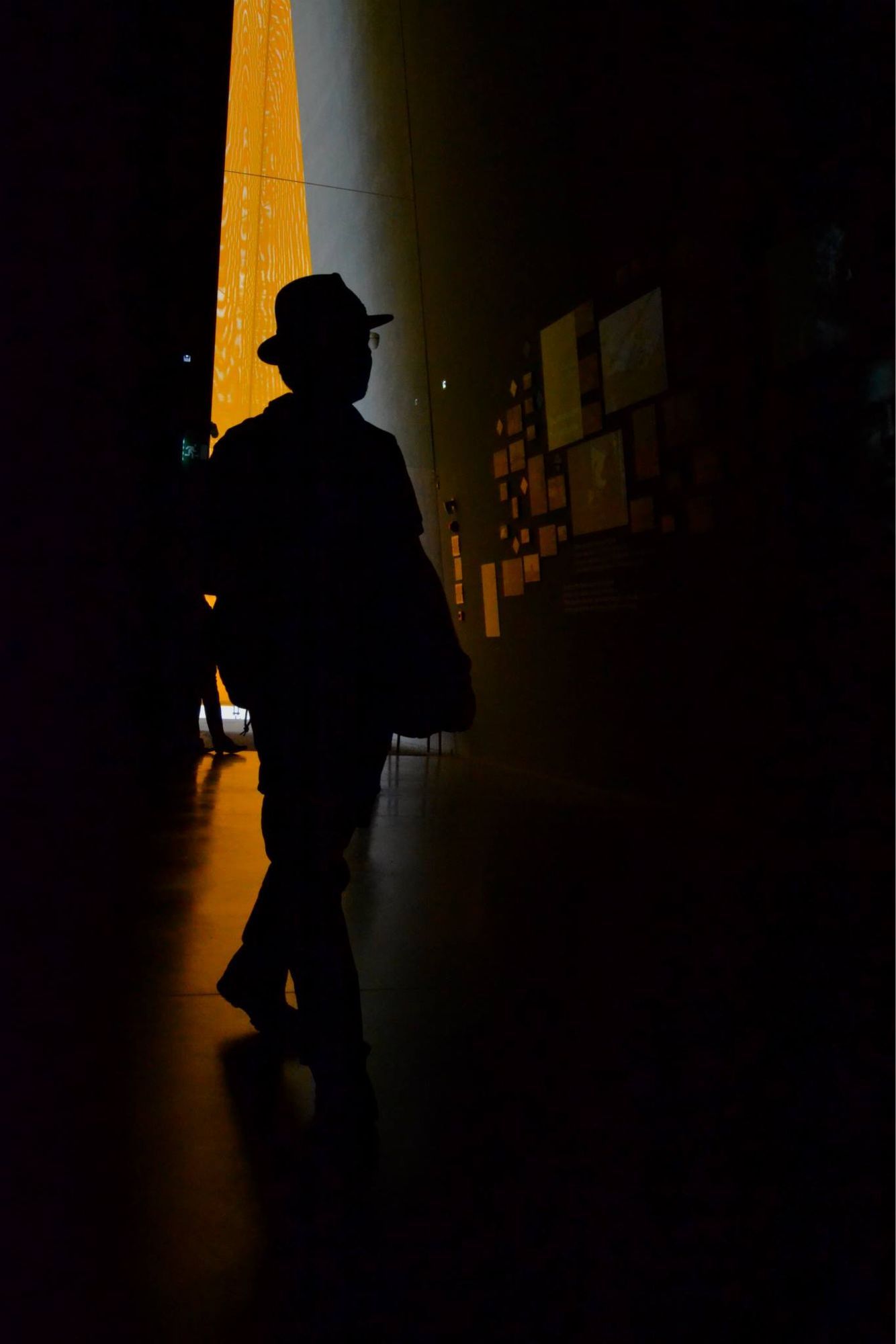 Silhouette di un uomo con il cappello in una sala di museo