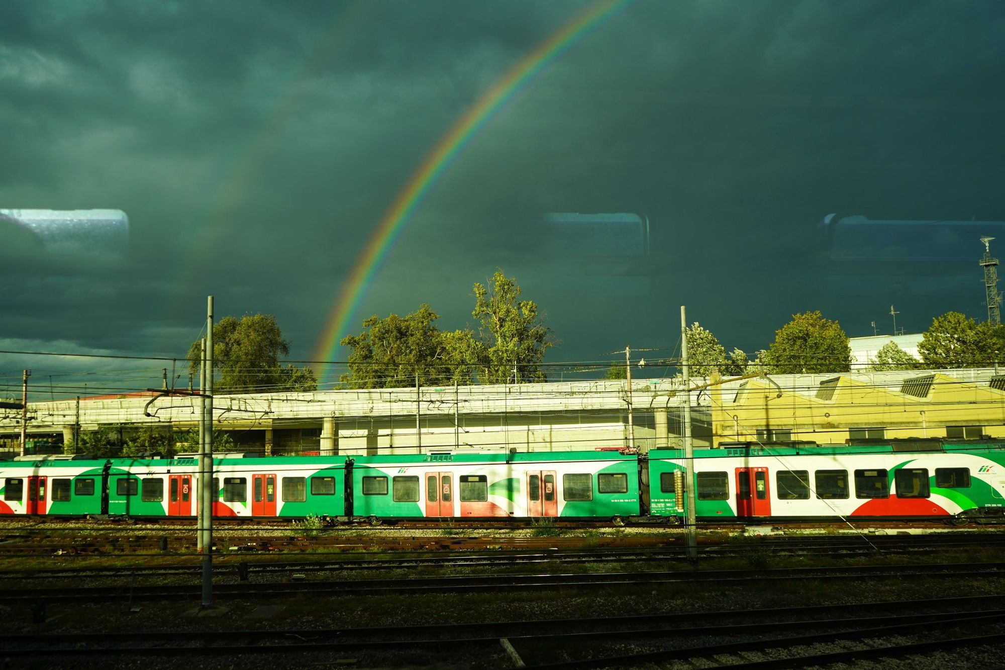 Arcobaleno sopra un treno regionale in stazione